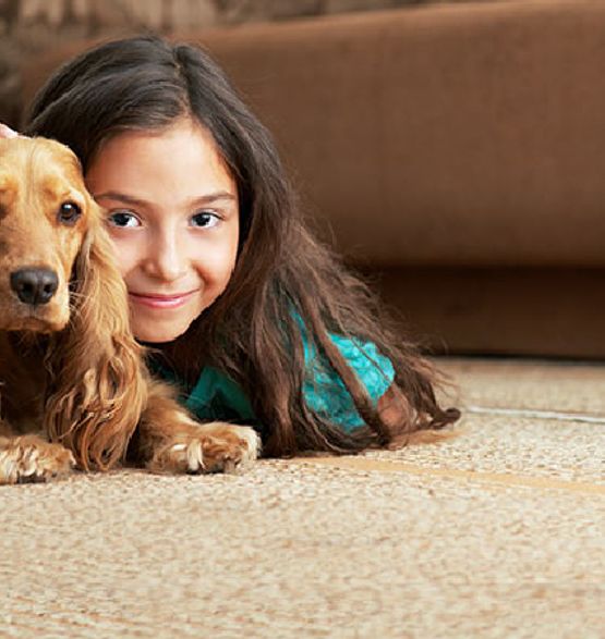 Girl sitting with her pet on a freshly cleaned carpet