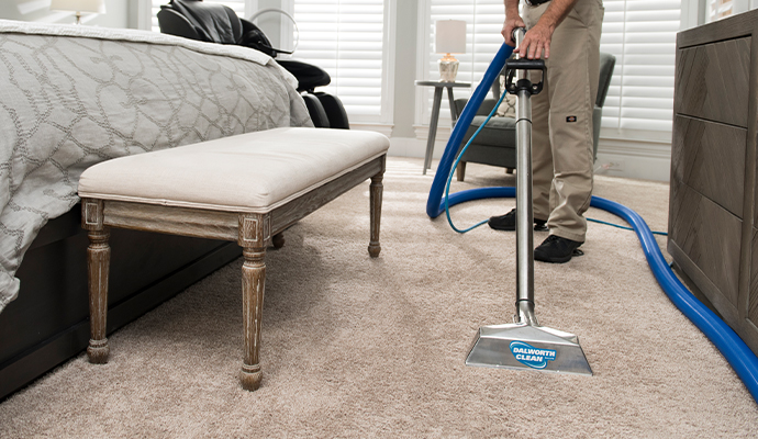 Person cleaning carpet with equipment Person cleaning carpet with equipment