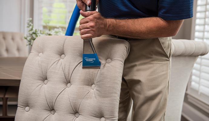 Professional upholstery cleaning on a tufted chair